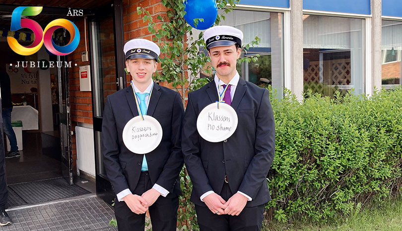 Två studenter framför skola.