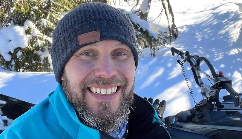 Man på skoter i skog.